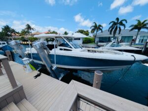 Small boat on lift, dockside installation with green water.