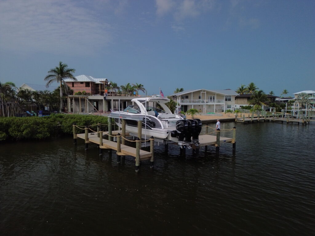 Aerial view of boat lift system installed at a dock, water in background.